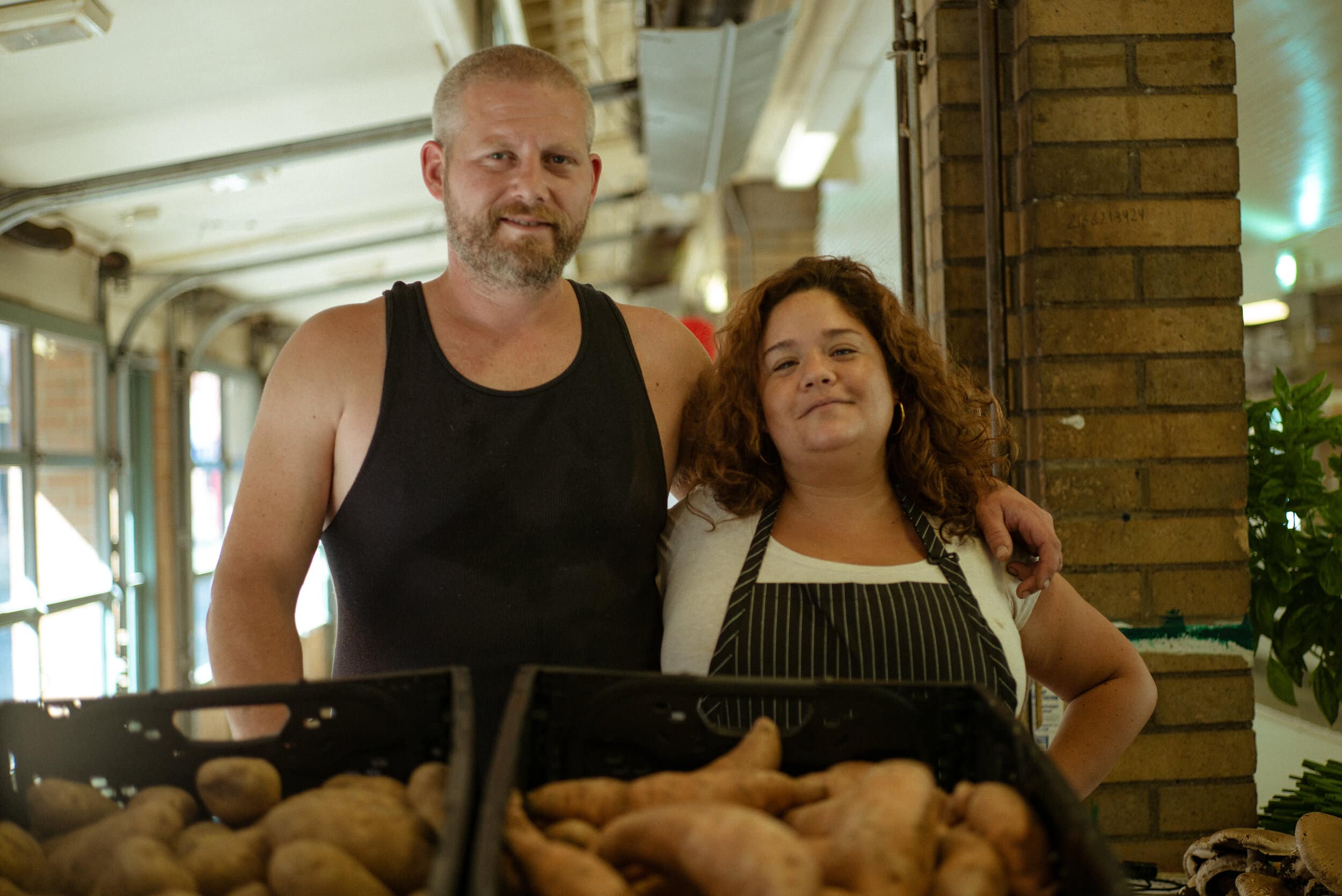 Rosie Galaz and her husband Will Norris pose for a portrait at the day stall for their urban farming business, The Tomato Guys. Photo by Michael Indriolo.
