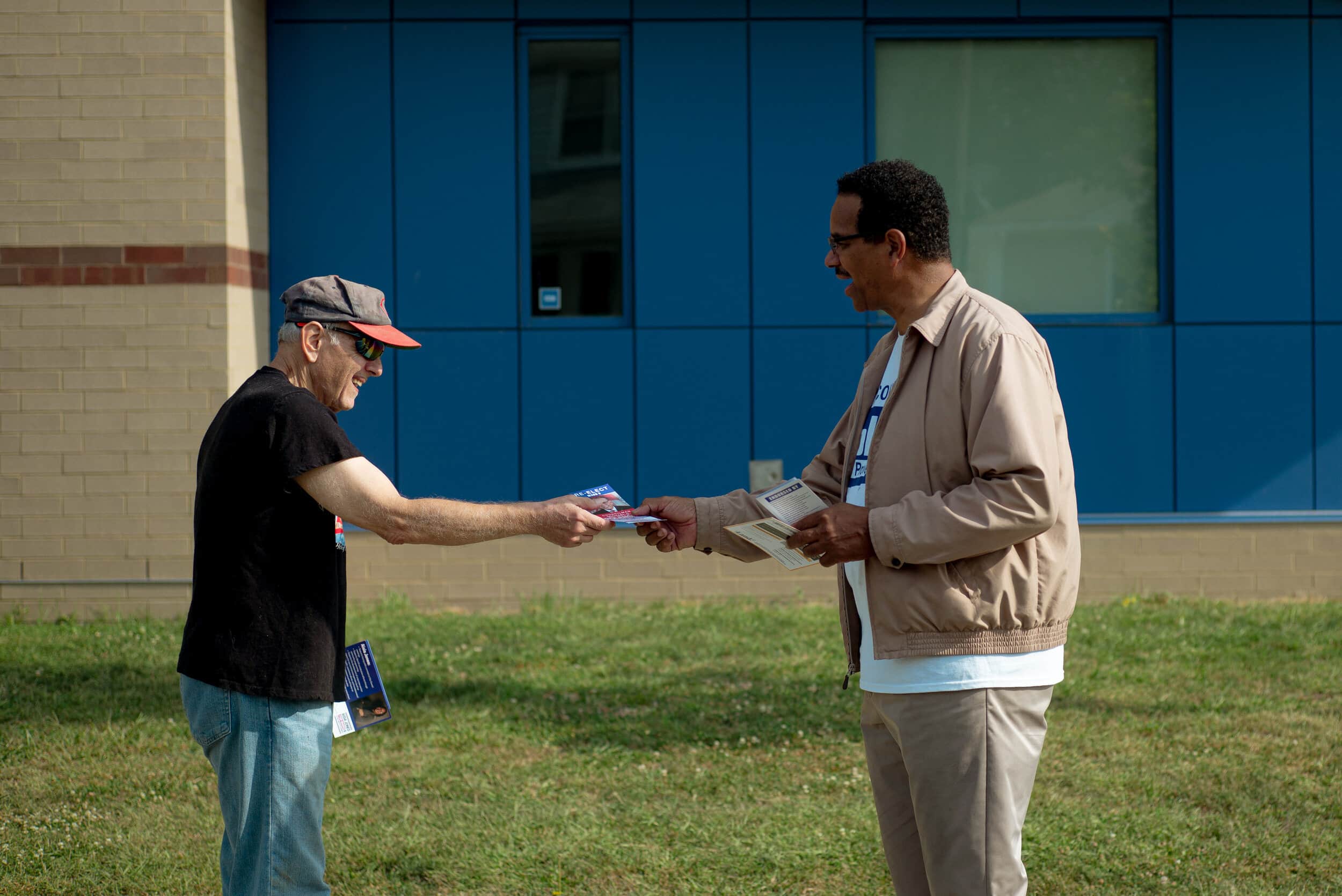 Campaigning for Ward 8 city council incumbent Mike Polensek, Lawrence Hill hands a flier to Ward 8 voter George Kovacs at the Oliver Hazard Perry elementary school on Tuesday, Sept. 14, 2021. Photo by Michael Indriolo