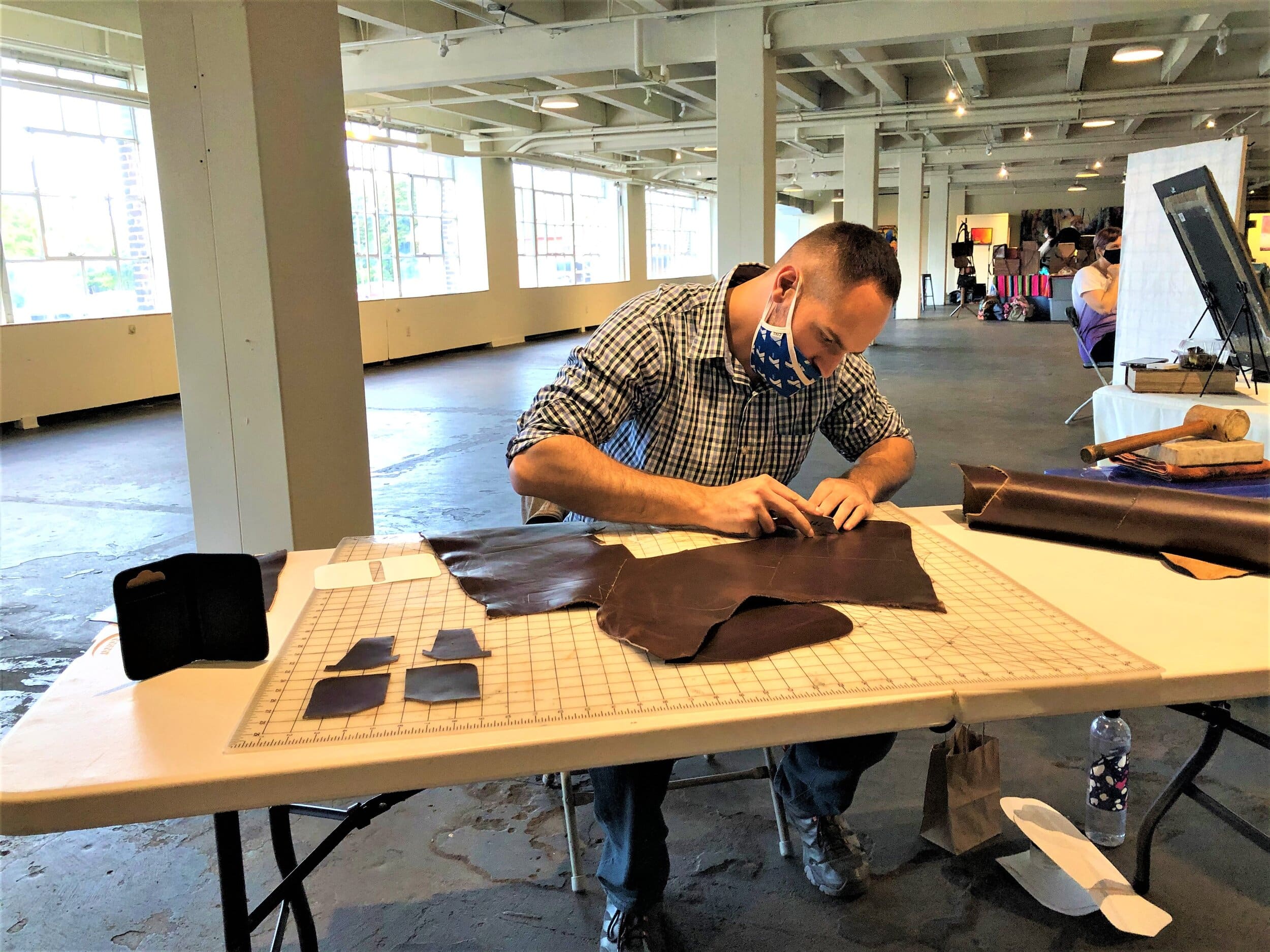 Ben Altemus makes leather goods during a Third Friday reception at the 78th Street Studios. Photo courtesy Grant Segall.