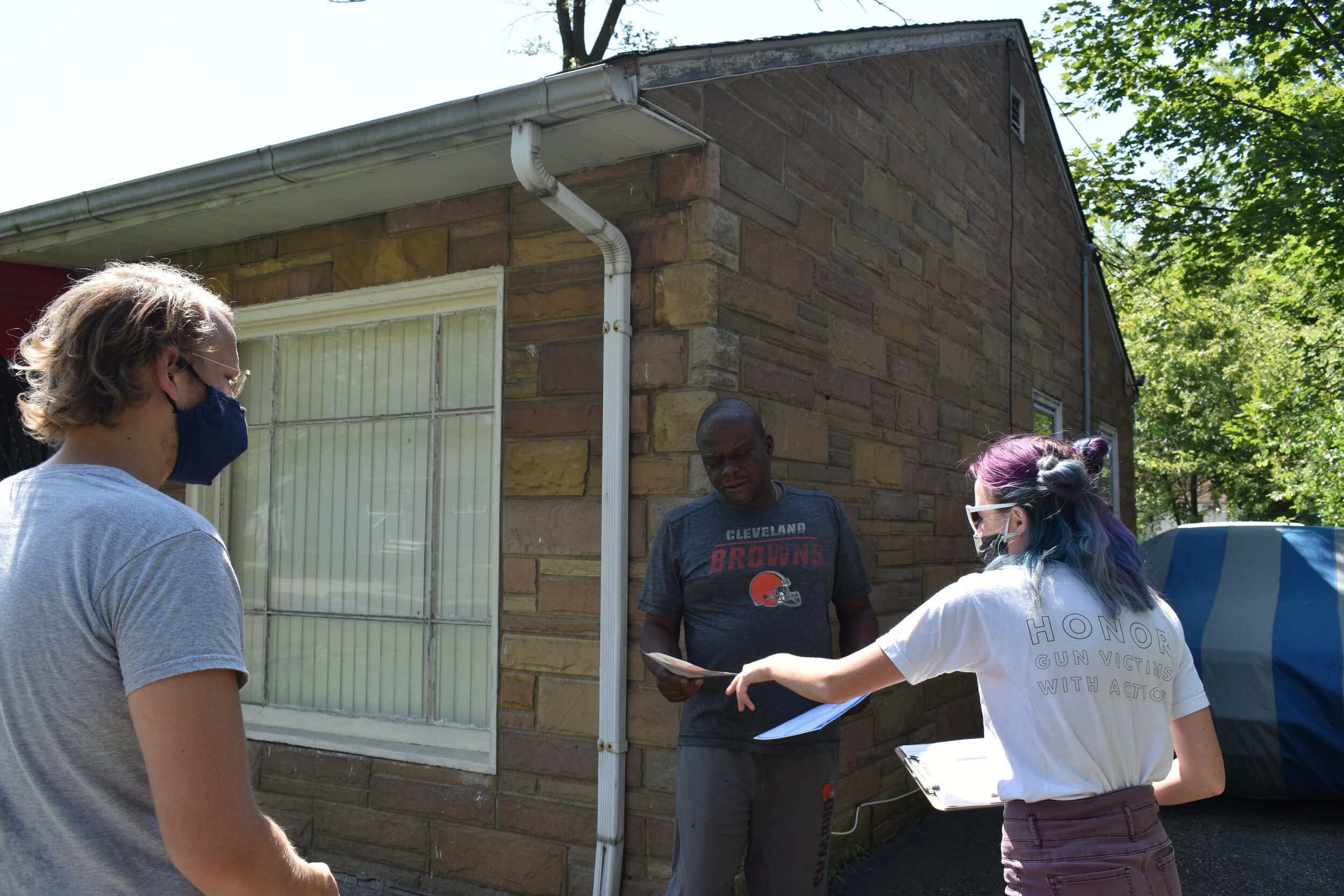 Cleveland resident Frank Hawkins (middle) talks to Cleveland DSA members Chad Falatic (left) and Anna Powaski (right) about the problems he was having with his landlord in August. Photo by Conor Morris.