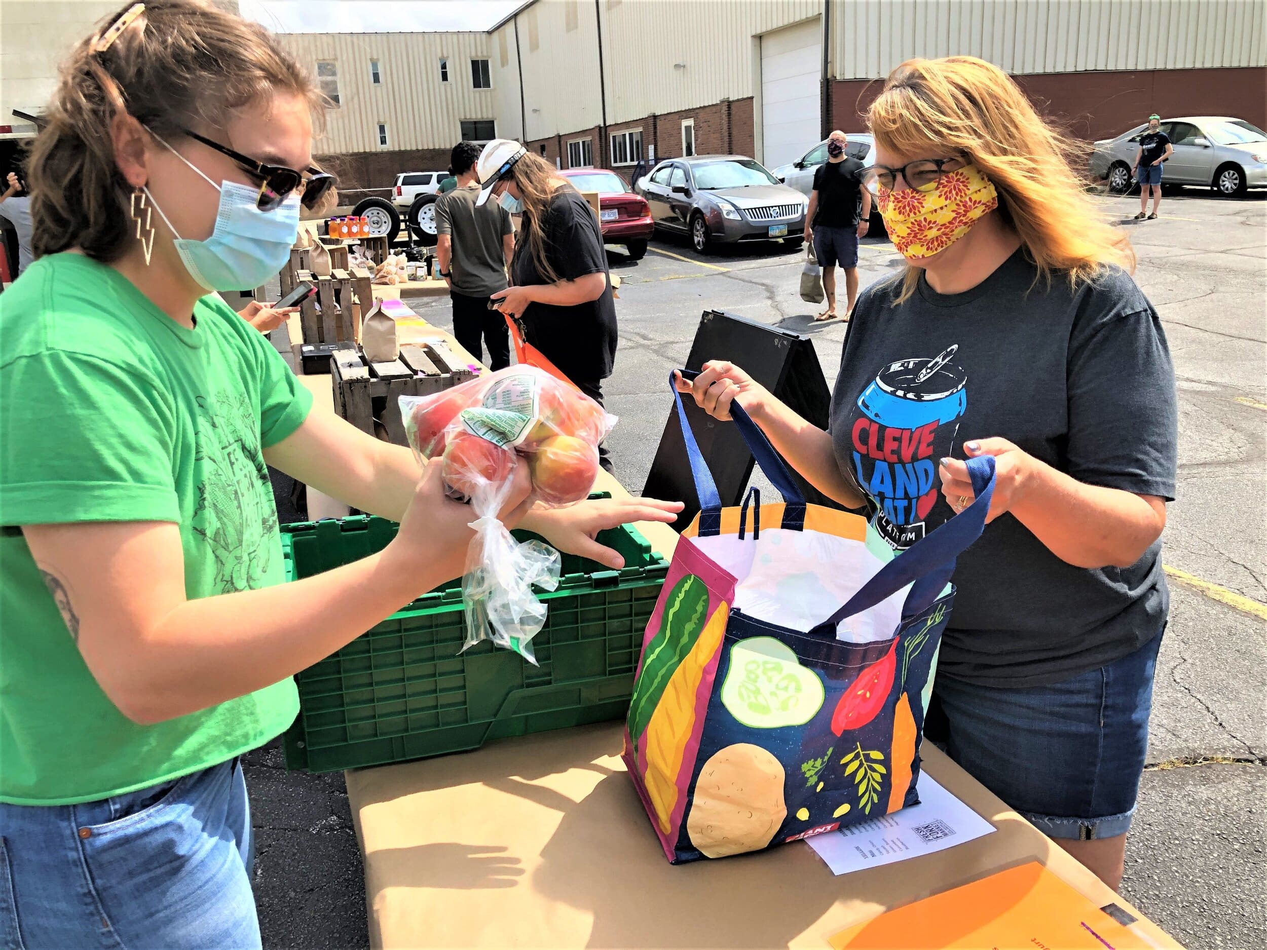Katie Farr of Fresh Fork hands peaches to Pat Pulizzi outside Lakewood's Screw Factory..jpg