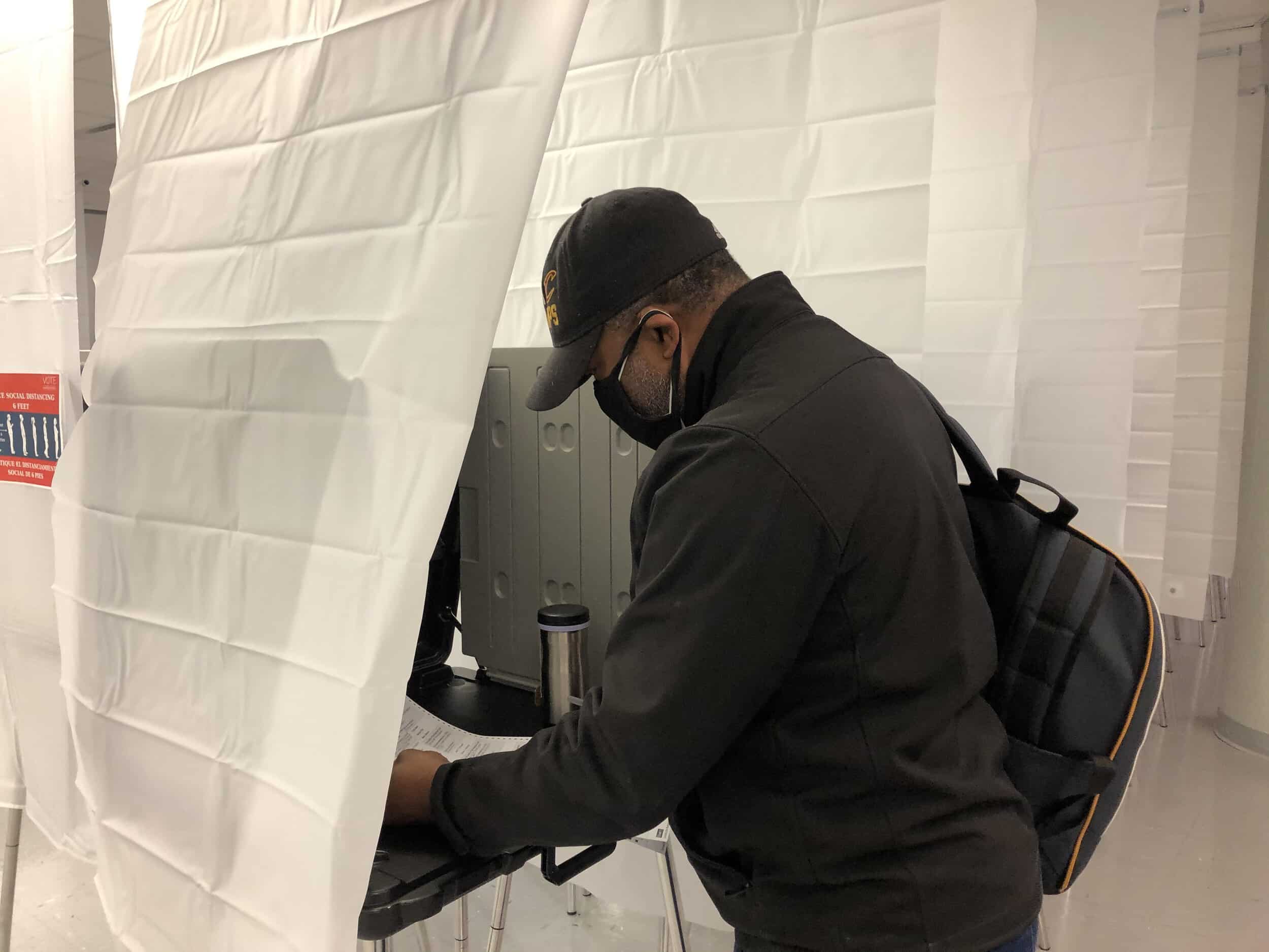 Ken Talley, the first person in line today for early voting, casts his ballot at board of elections.