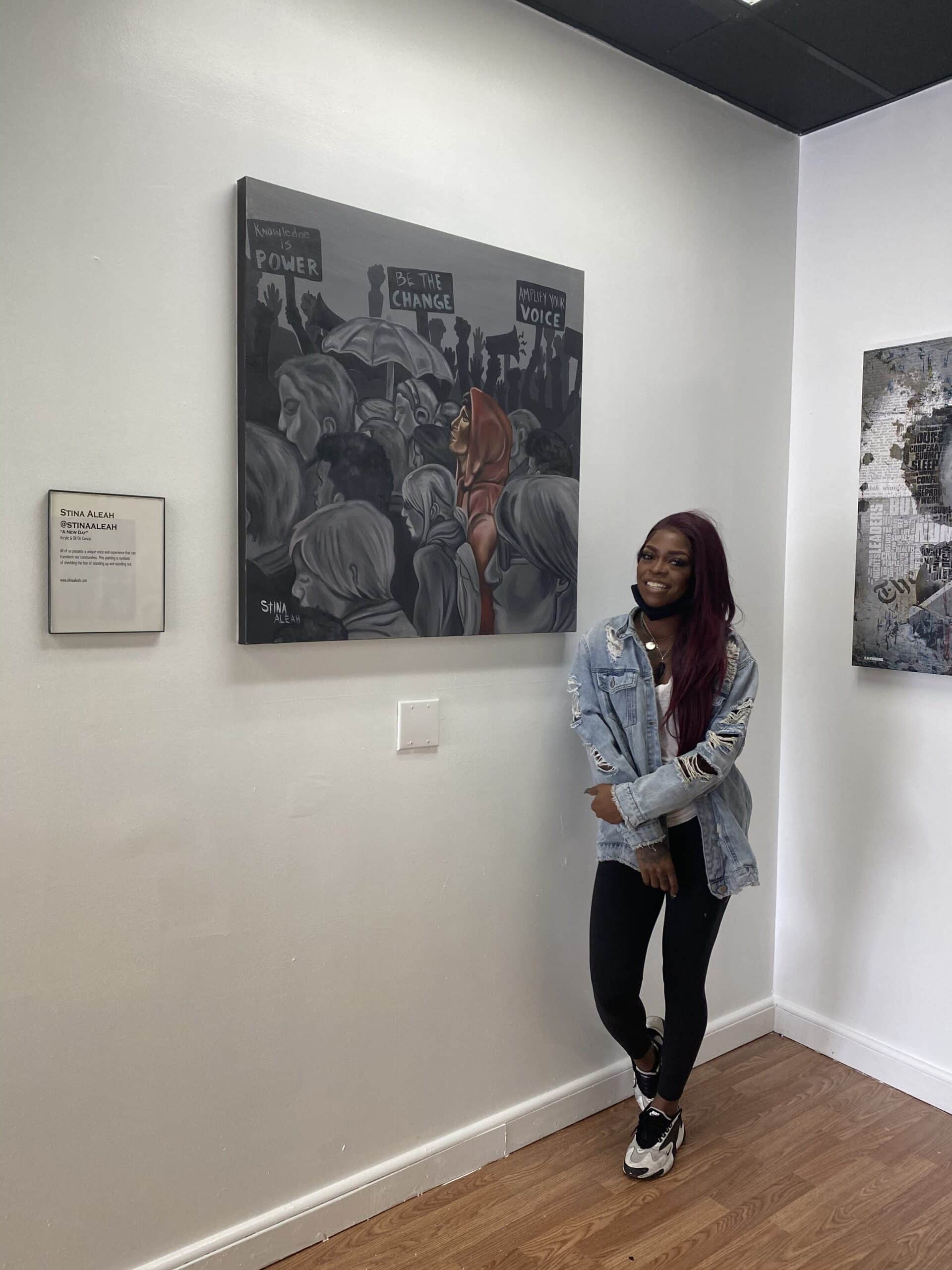  Stina Aleah in front of her painting “A New Day” at I See Voices 