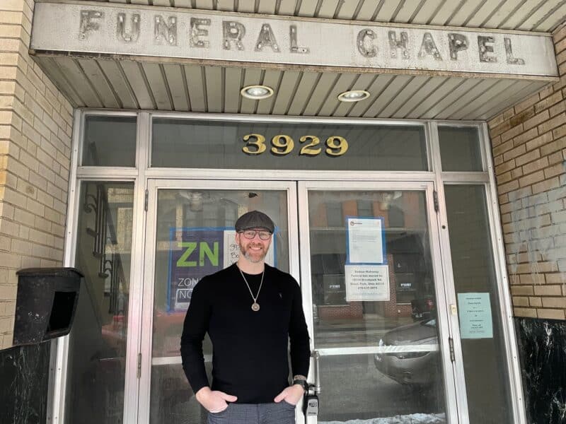 Zach Cooper stands in front of the former funeral building at 3929 Lorain Ave., future home of Sartorial