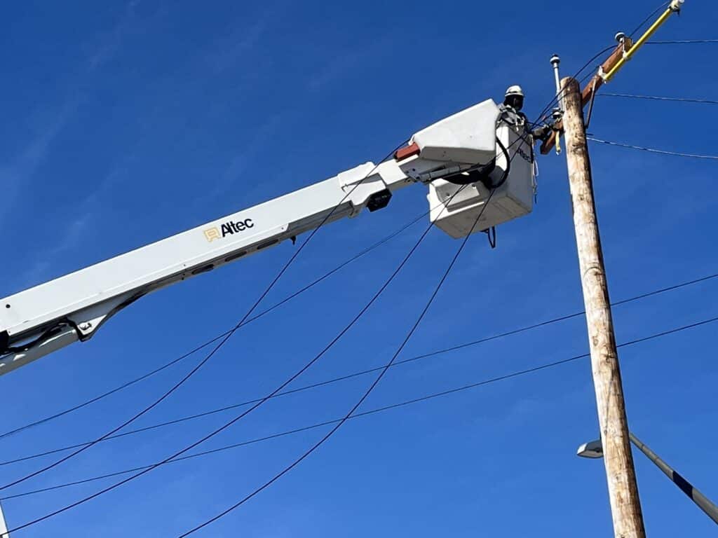 Ta’Jahnae Buchanan working on power lines from a spot high up in a bucket truck.