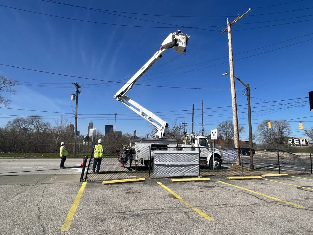 Ta'Jahnae Buchanan descends back to the ground in the arm of the bucket truck as her co-workers watch from the ground.