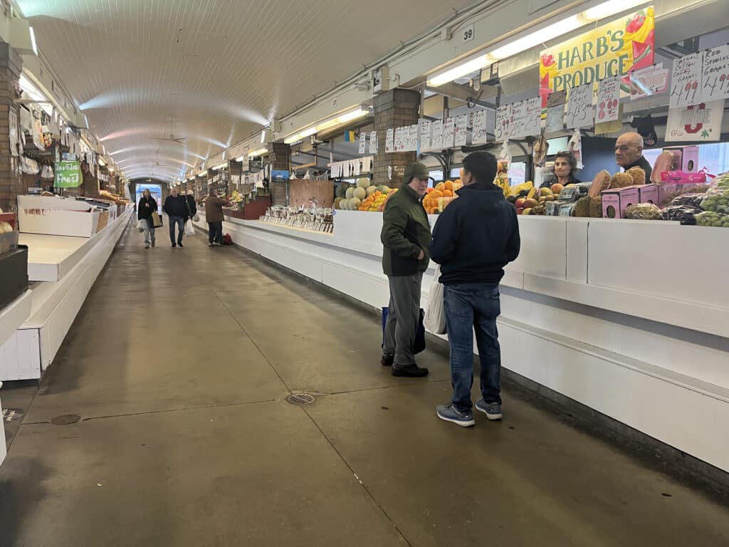 Customers talking near Harb's Produce in the Arcade section of the market. 