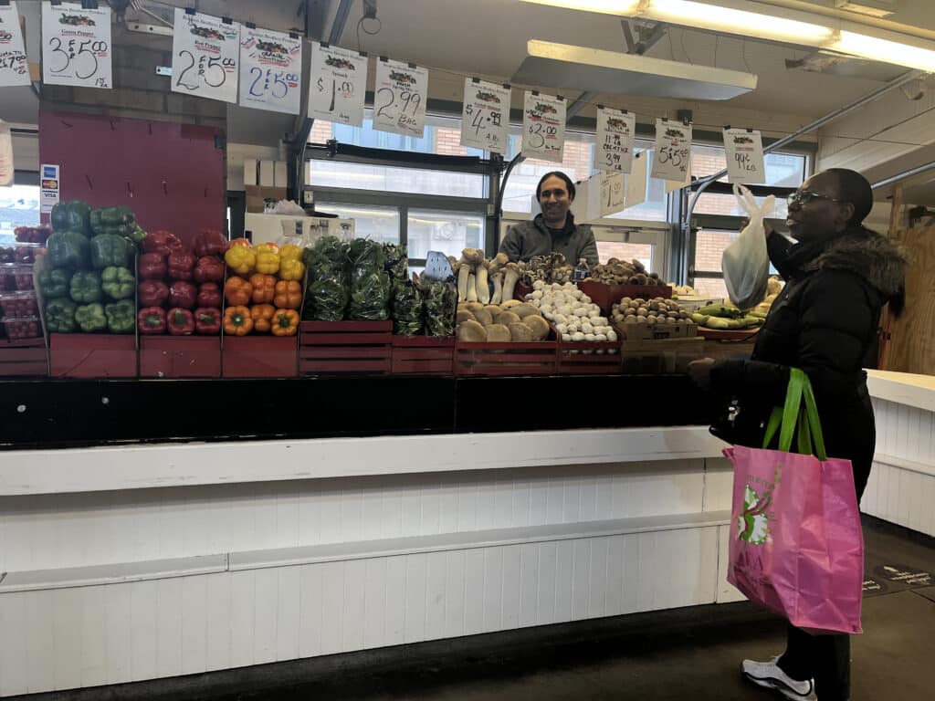 Tom Boutros of Boutros Brothers Produce serves a customer. 