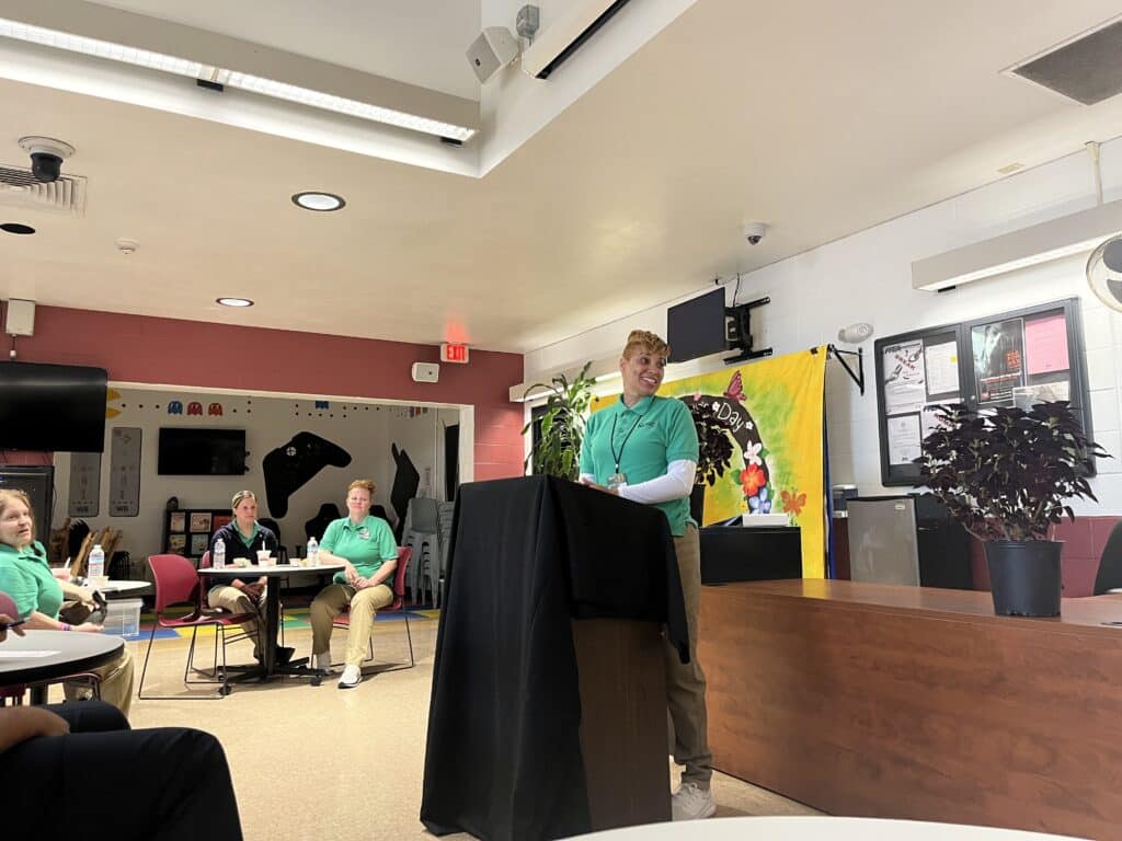 Karenda Hutsenpiller smiling while standing at the podium during a ribbon-cutting ceremony for the Ohio Means Jobs Center at the Northeast Reintegration Center. 