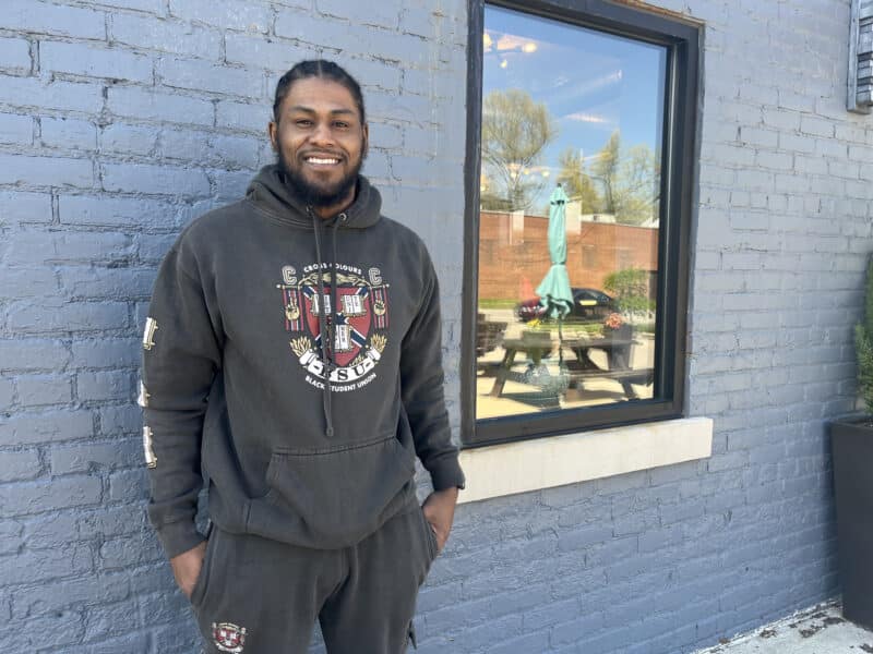 Friend A Felon founder Sterling Braden standing near a gray brick wall and a window.