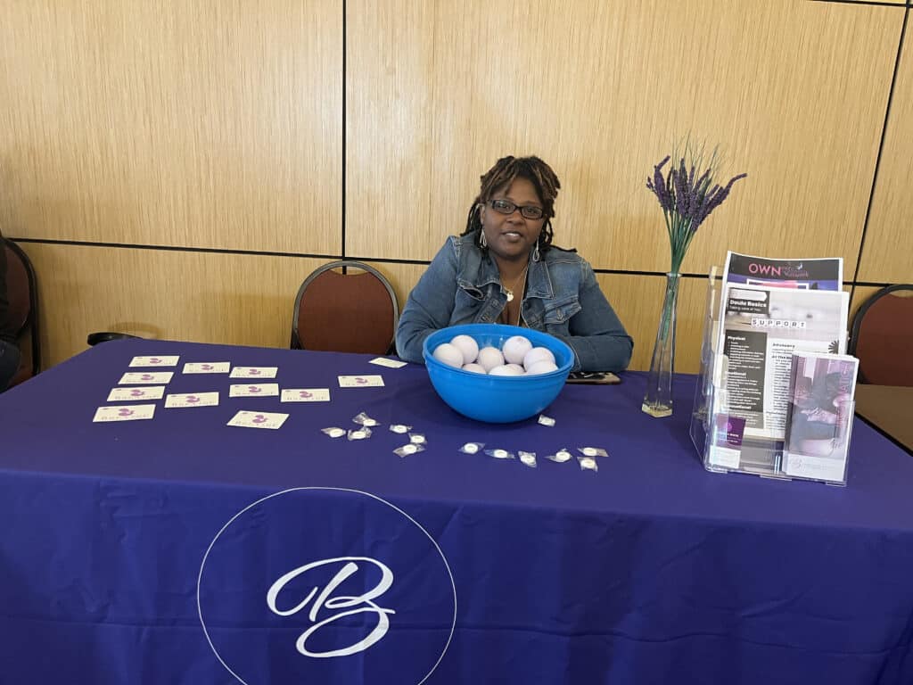 LaTanisha White smiling for a photo at the Birthing Beautiful Communities booth at the Community Health Worker Day. 