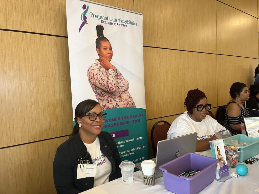 Takiyah Durham smiling for a photo at the Pregnant with Possibilities booth at the Community Health Worker Day. 