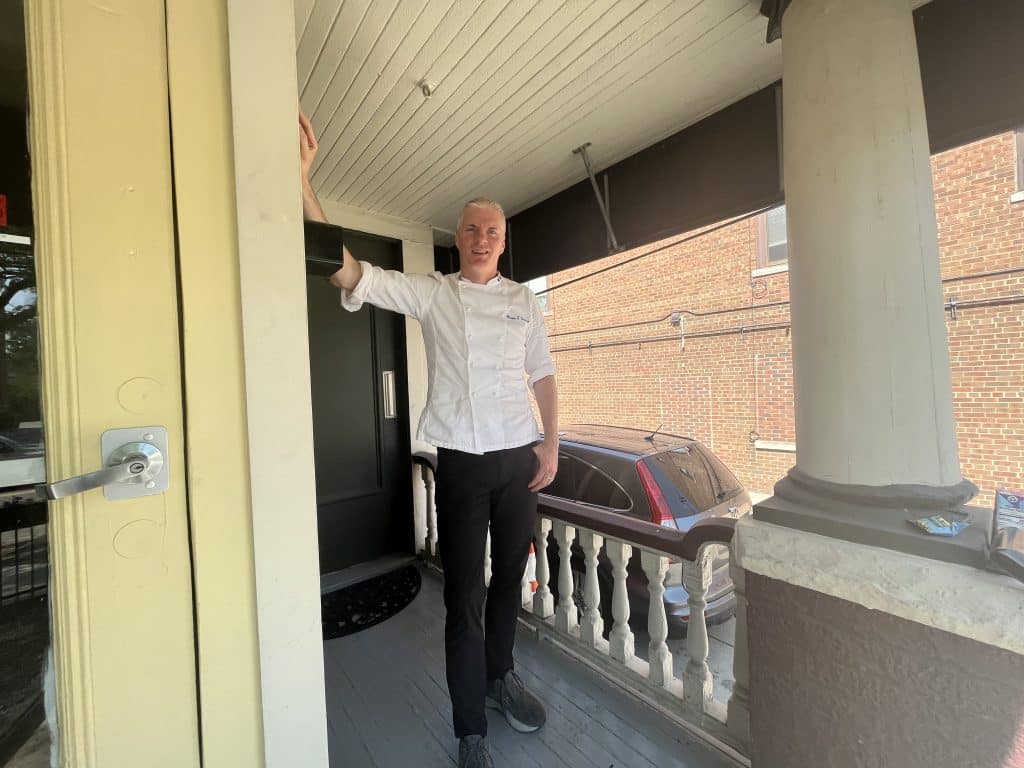 EDWINS founder Brandon Chrostowski posing for a photo on the porch of the EDWINS Family Center.