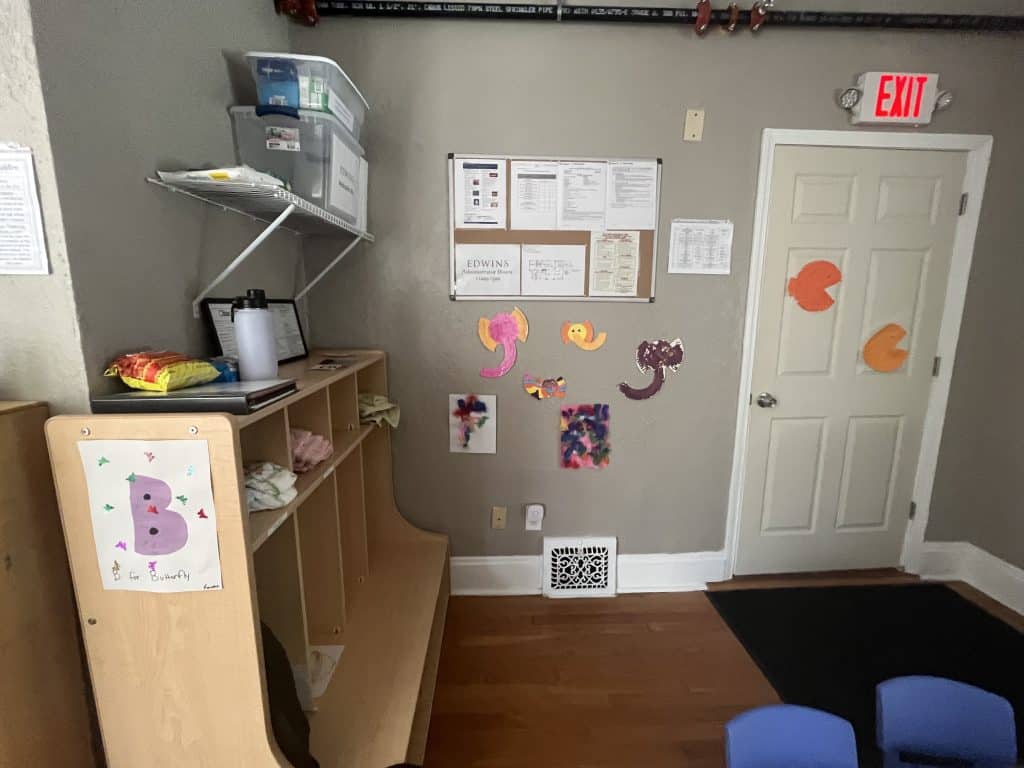 Children's art work hangs on a cubby and the wall near the door to the family center.