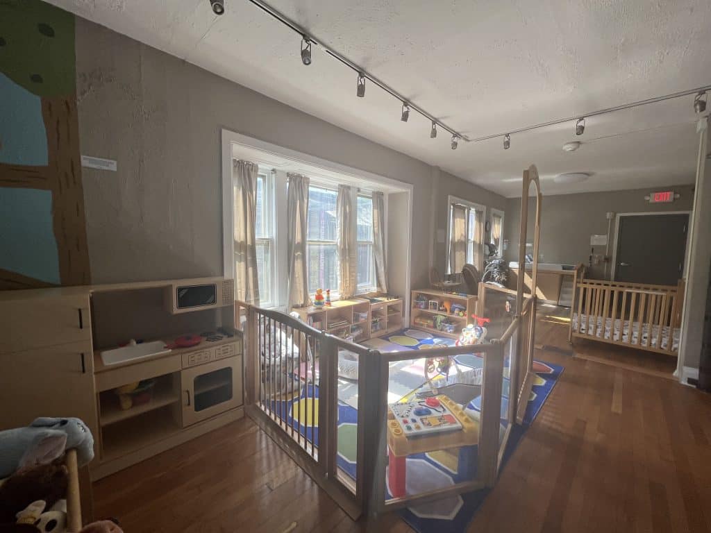 A fenced-in play area with shelves of toys.