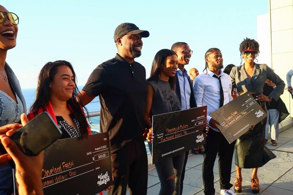 Entrepreneurs holding their surprise checks and smiling for a photo with Mayor Justin Bibb and the founders of Tastemakers.