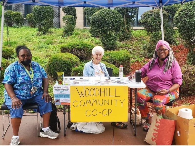 Four Woodhill Community Co-op members sitting around a table during a co-op meeting.