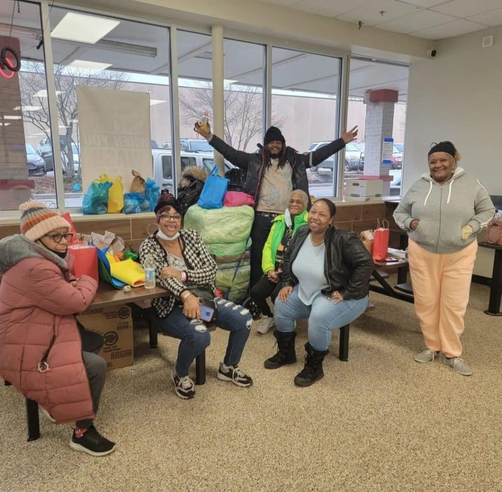 Laundry day attendees near tables at a laundromat posing for a photo.