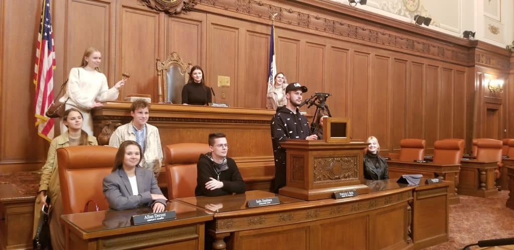 Students posing for a photo in the Cleveland City Hall council chambers. 