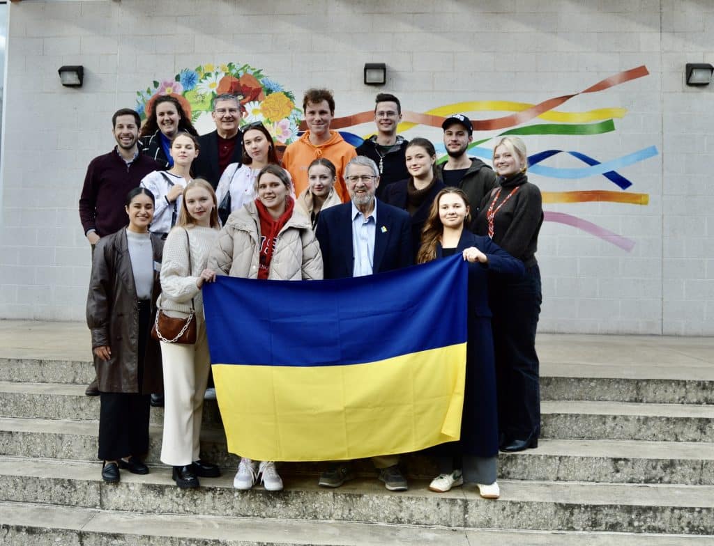 Students pose with the Ukrainian flag, Cleveland Council on World Affairs staff, and Ukrainian Museum-Archives director Andy Fedynsky at the museum in Tremont. 