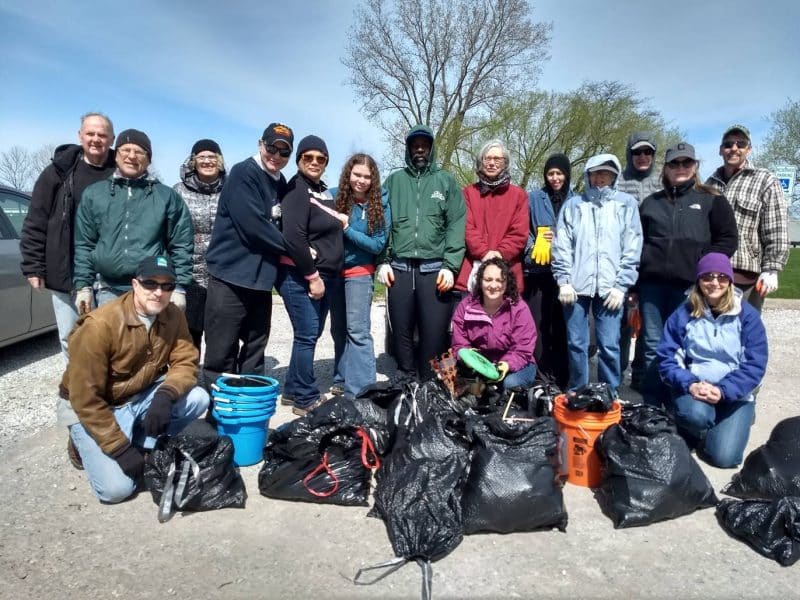 Group of people outside picking up litter in public