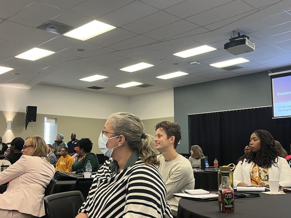 Attendees of the April 28 town hall meeting sitting at tables during an audience Q&A.