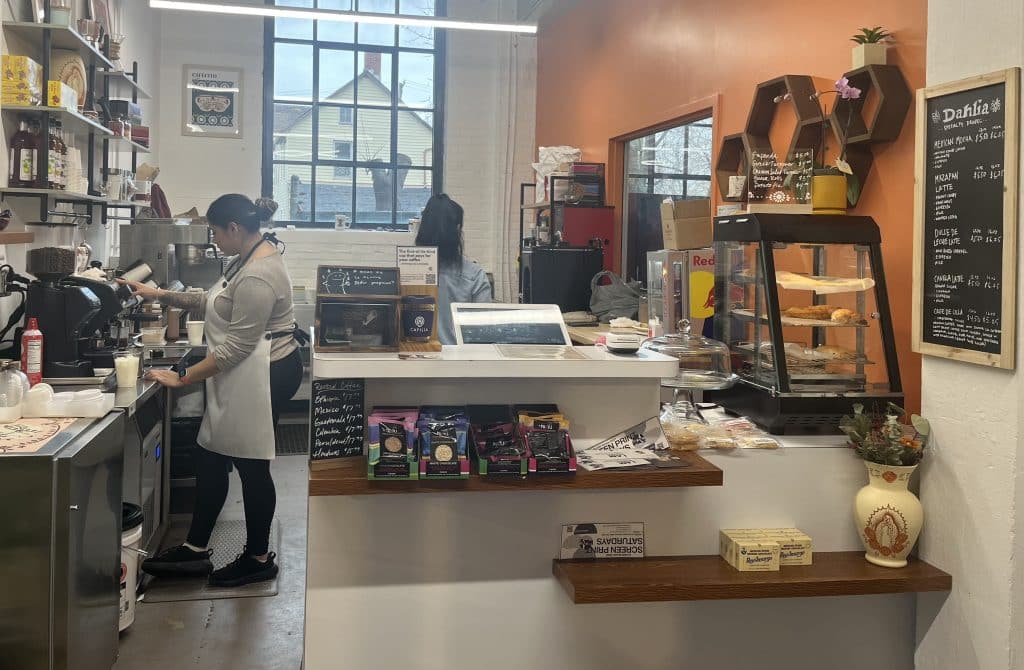 Natalia Alcazar and a Dahlia Coffee Co. employee working behind the counter at the coffee shop.